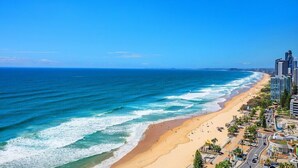 Un paisaje urbano costero con playa, océano y rascacielos.