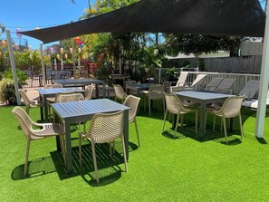 Enjoy al fresco dining and socializing in this shaded patio area surrounded by lush greenery.