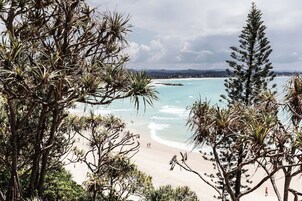 Una playa con agua turquesa cristalina, rodeada de densa vegetación tropical.