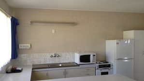 Una cocina compacta con microondas, horno y refrigerador.