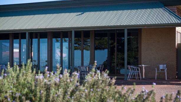 A building with large windows and outdoor seating. - Foreshore Motor Inn (Whyalla)