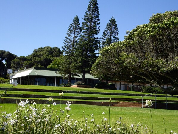 A building with a green roof, surrounded by well-maintained grass and trees. - Foreshore Motor Inn (Whyalla)
