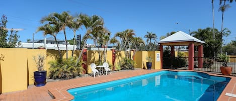 Una piscina al aire libre, tumbonas