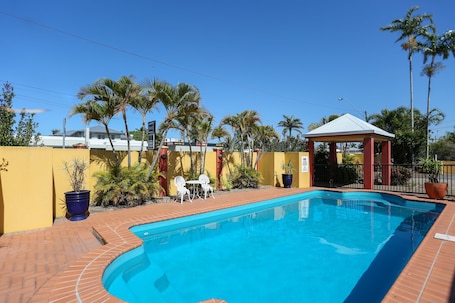 Una piscina al aire libre, sillones reclinables de piscina