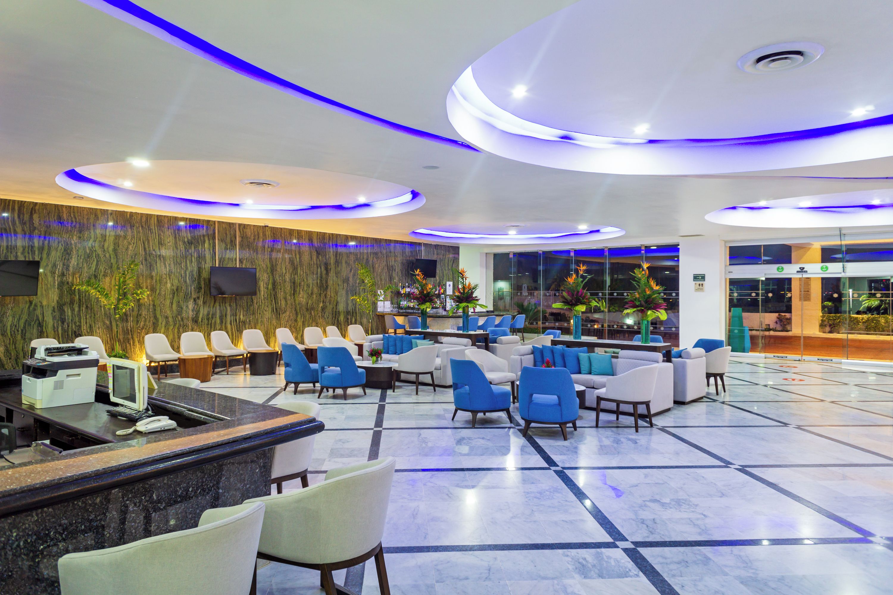 Eine Hotelhalle mit Rezeption, Sitzgelegenheit und Bar.