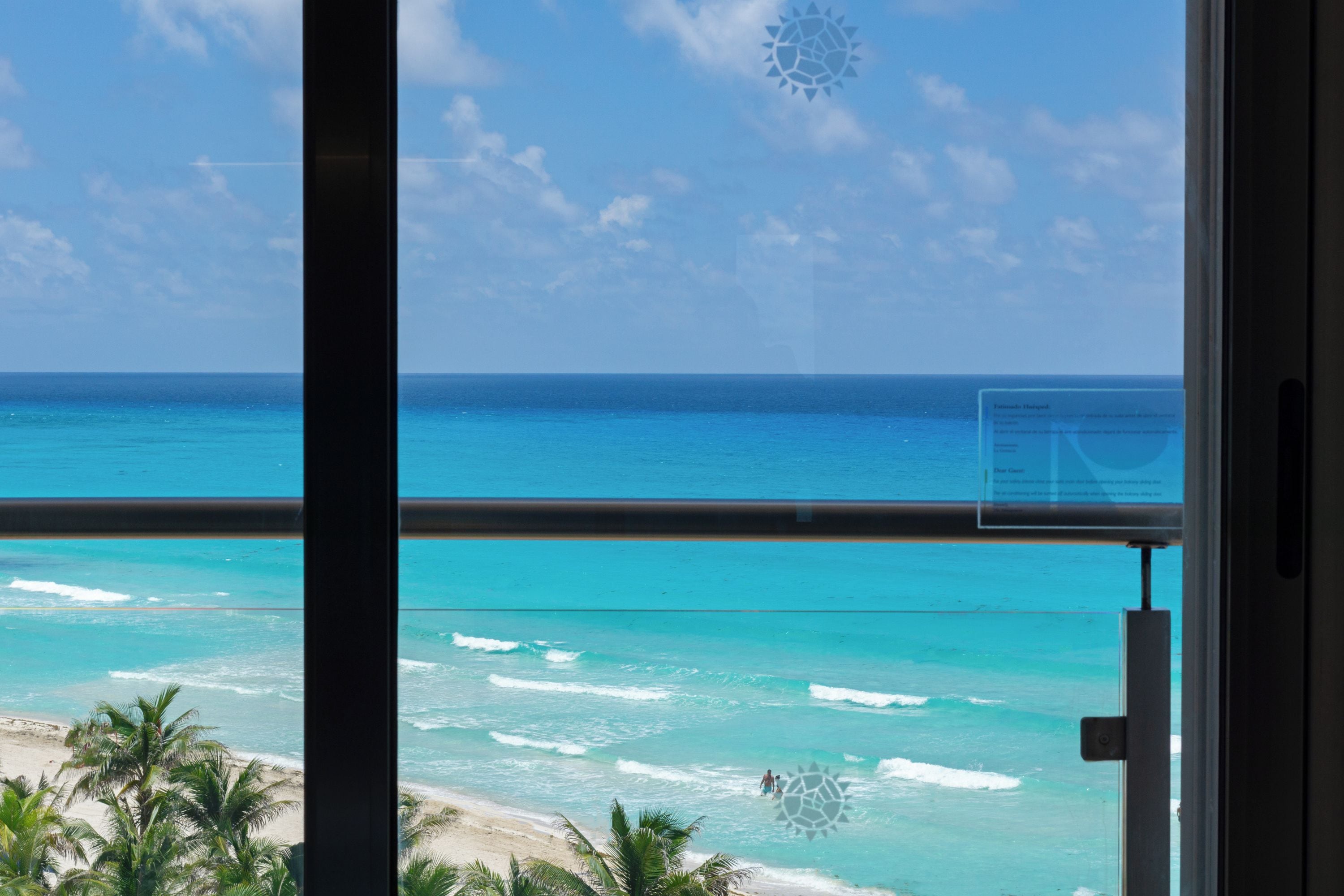 Vista de uma praia com águas azul-turquesa e palmeiras.