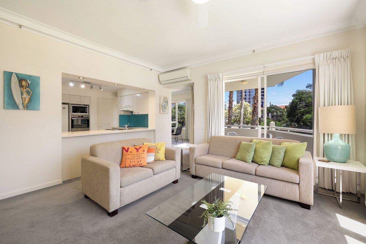Una sala de estar con sofá, una mesa de centro y vistas al exterior.