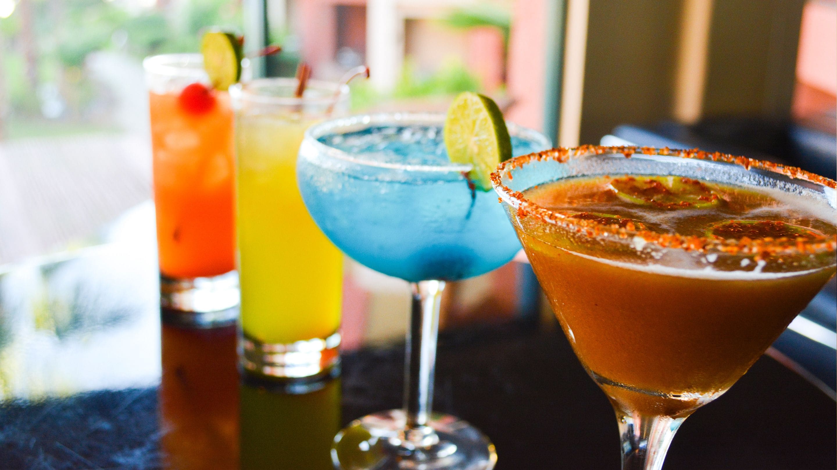 Drie cocktails op een bar.