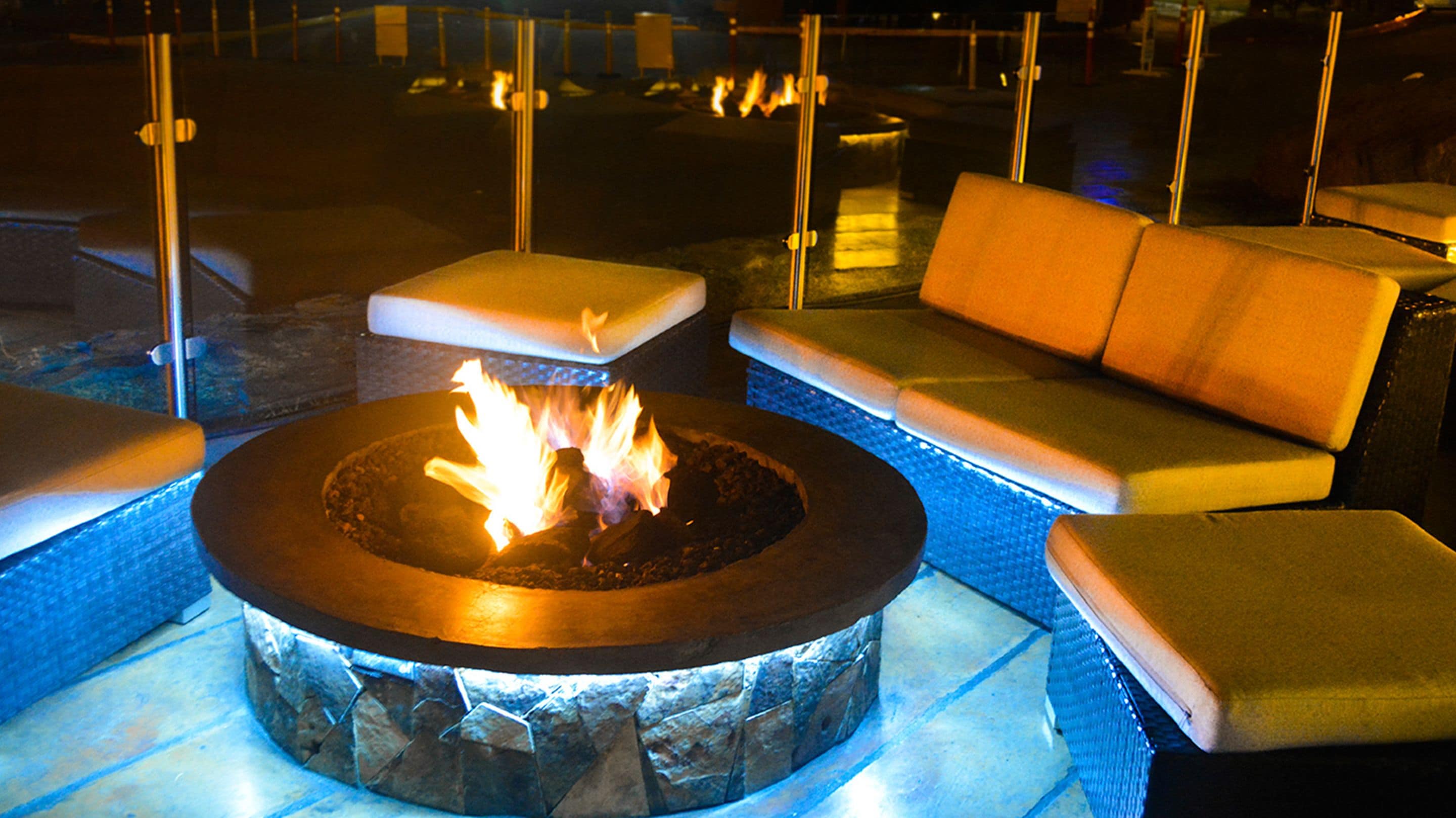 A fire pit surrounded by cushioned seating.