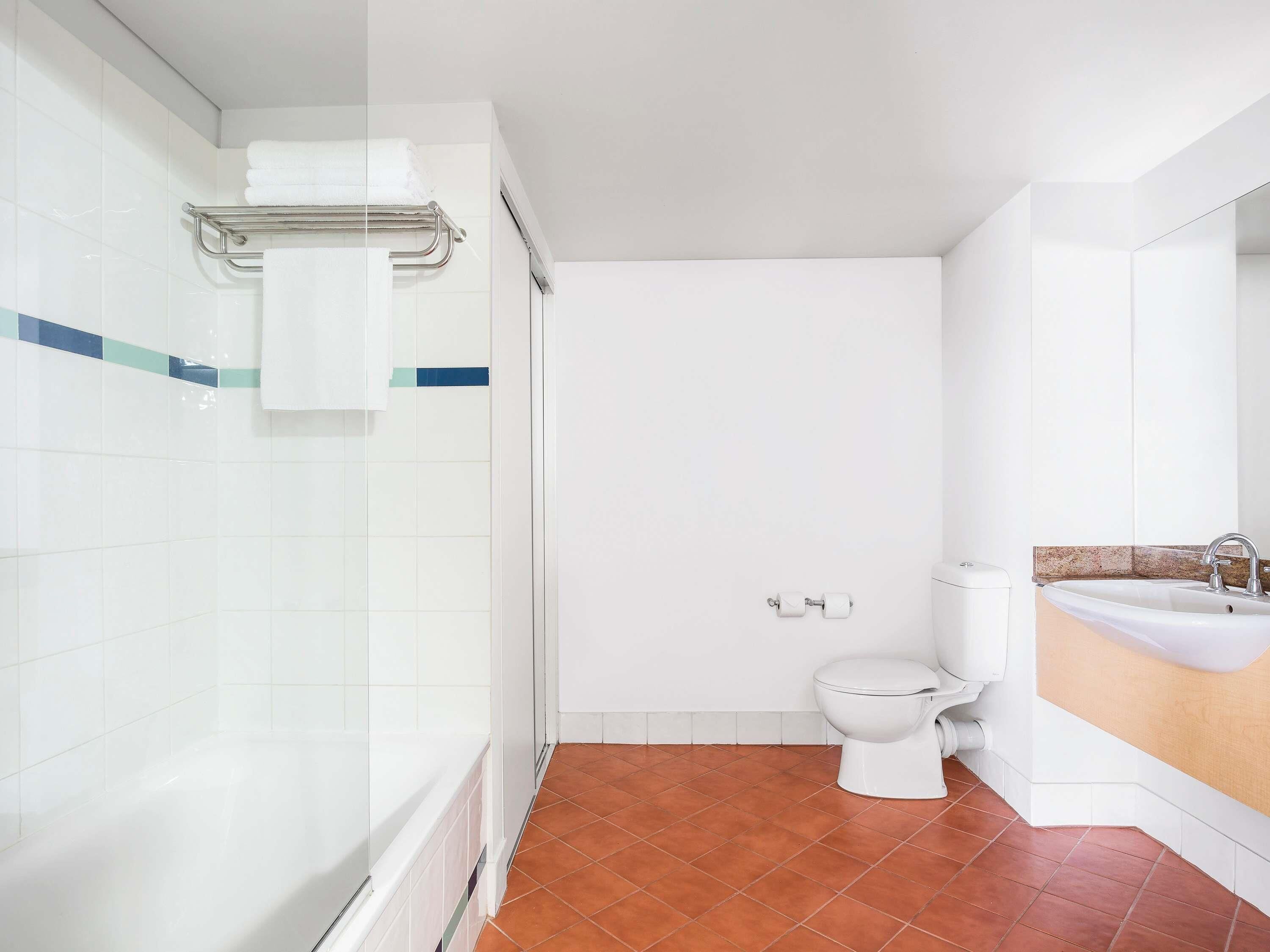Une salle de bain avec douche, toilettes et lavabo.