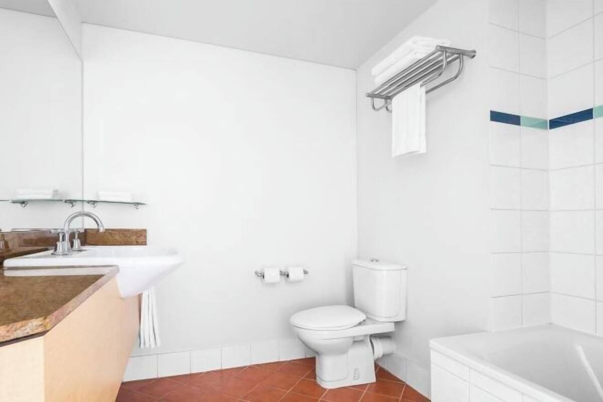 A modern bathroom with a sink, toilet, and bathtub.