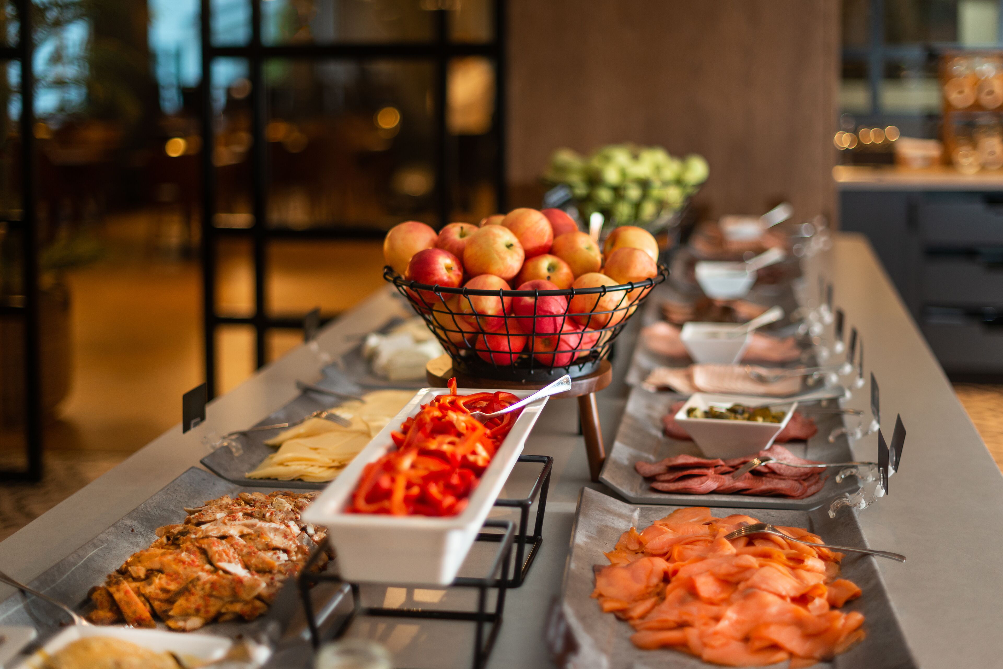 A buffet with various food items including fruits, meats, and vegetables.