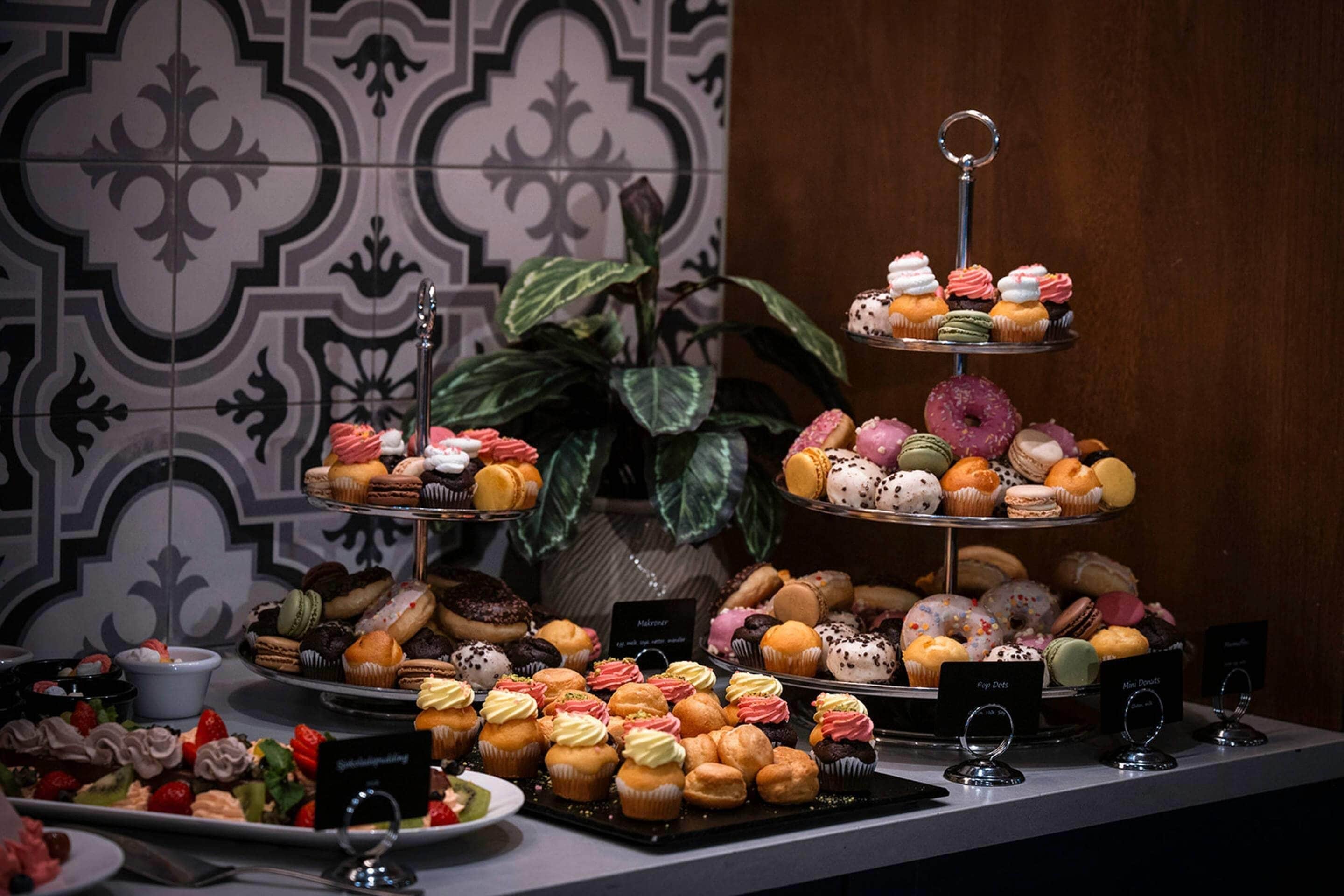 A display of various pastries and desserts on tiered stands.