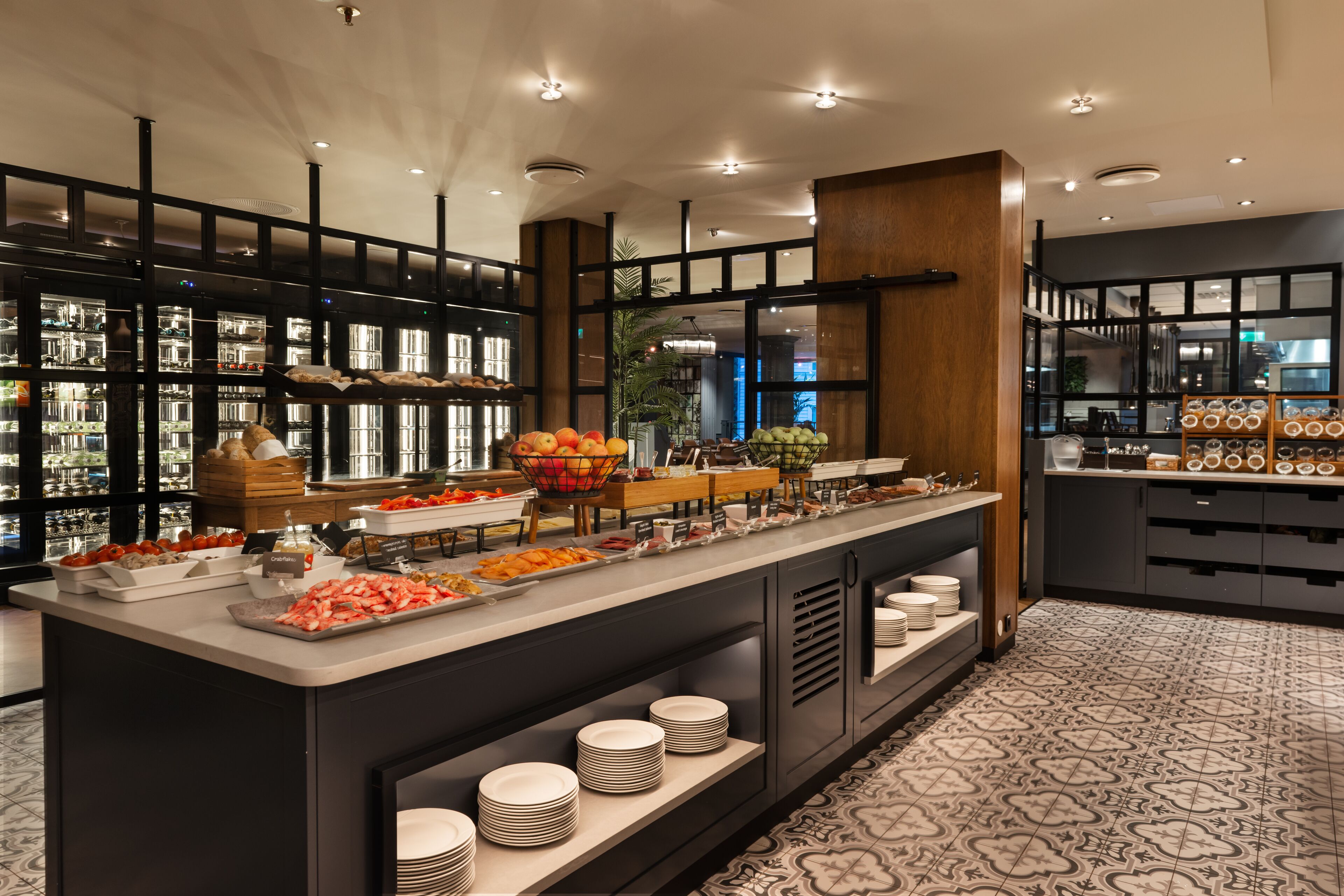 A buffet setup with various food items and a selection of plates.