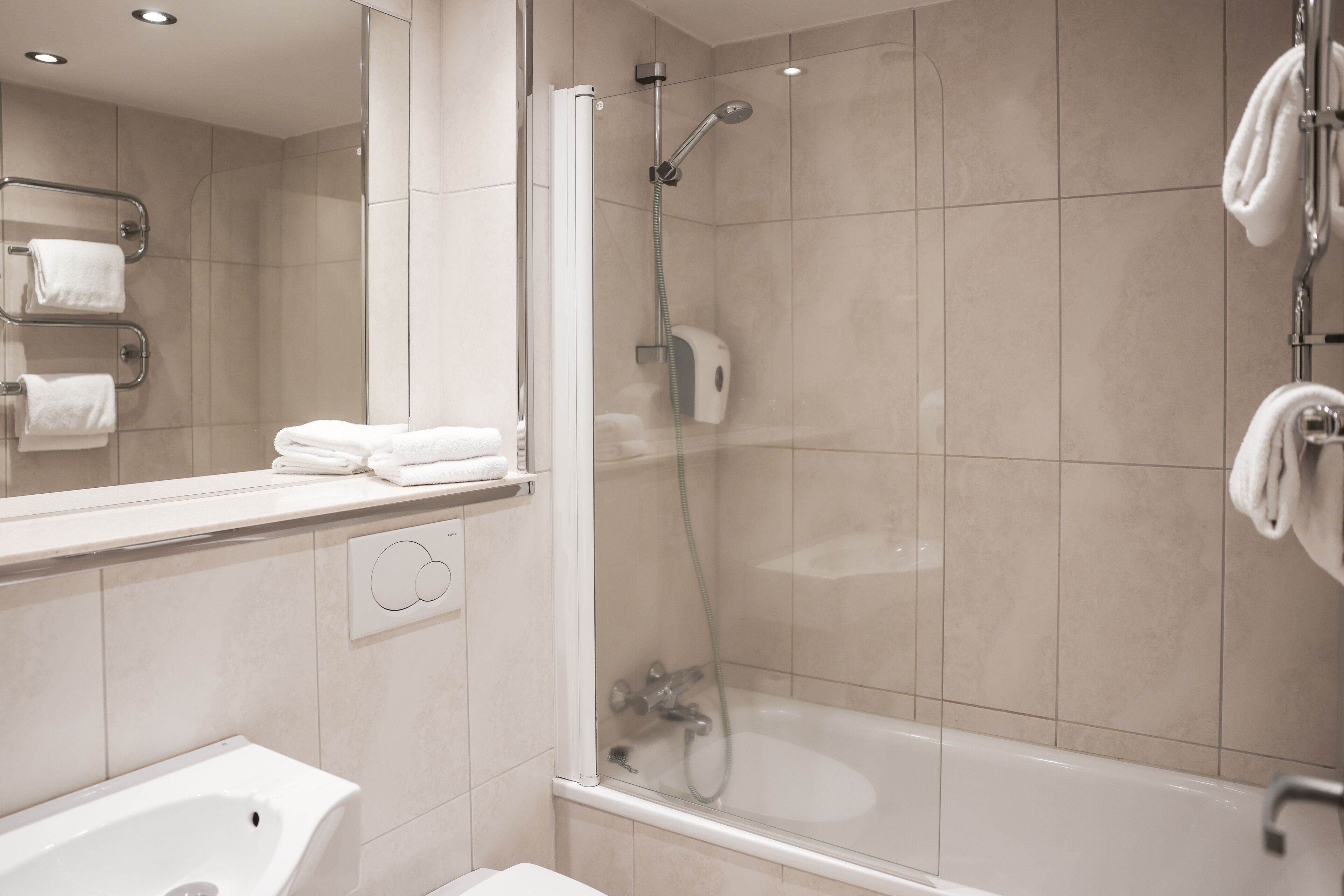A modern bathroom with a glass-enclosed shower, a sink, and a mirror.