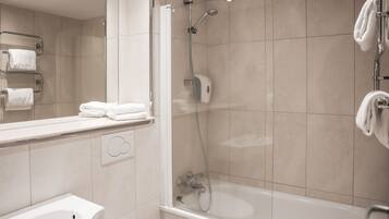 A modern bathroom with a glass-enclosed shower, a sink, and a mirror.