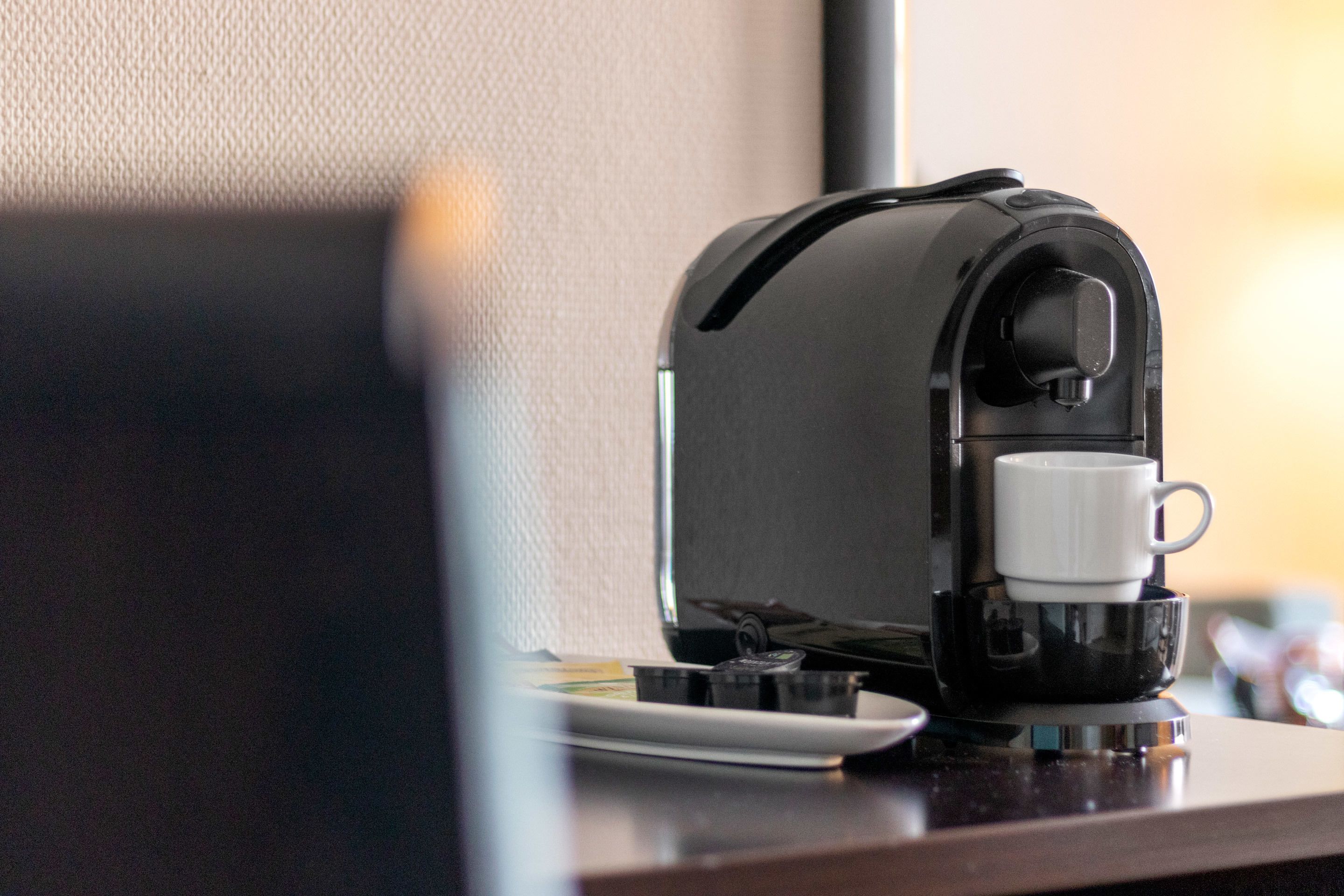 A coffee machine with a cup on the counter.