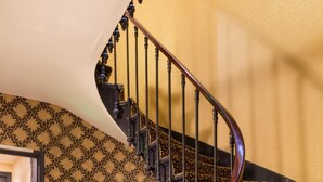 A spiral staircase with ornate metal railings and patterned carpet. - Hôtel Gaillon Opéra (Paris)