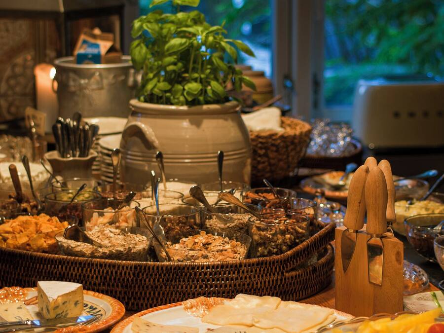 A buffet table with various food items and utensils.