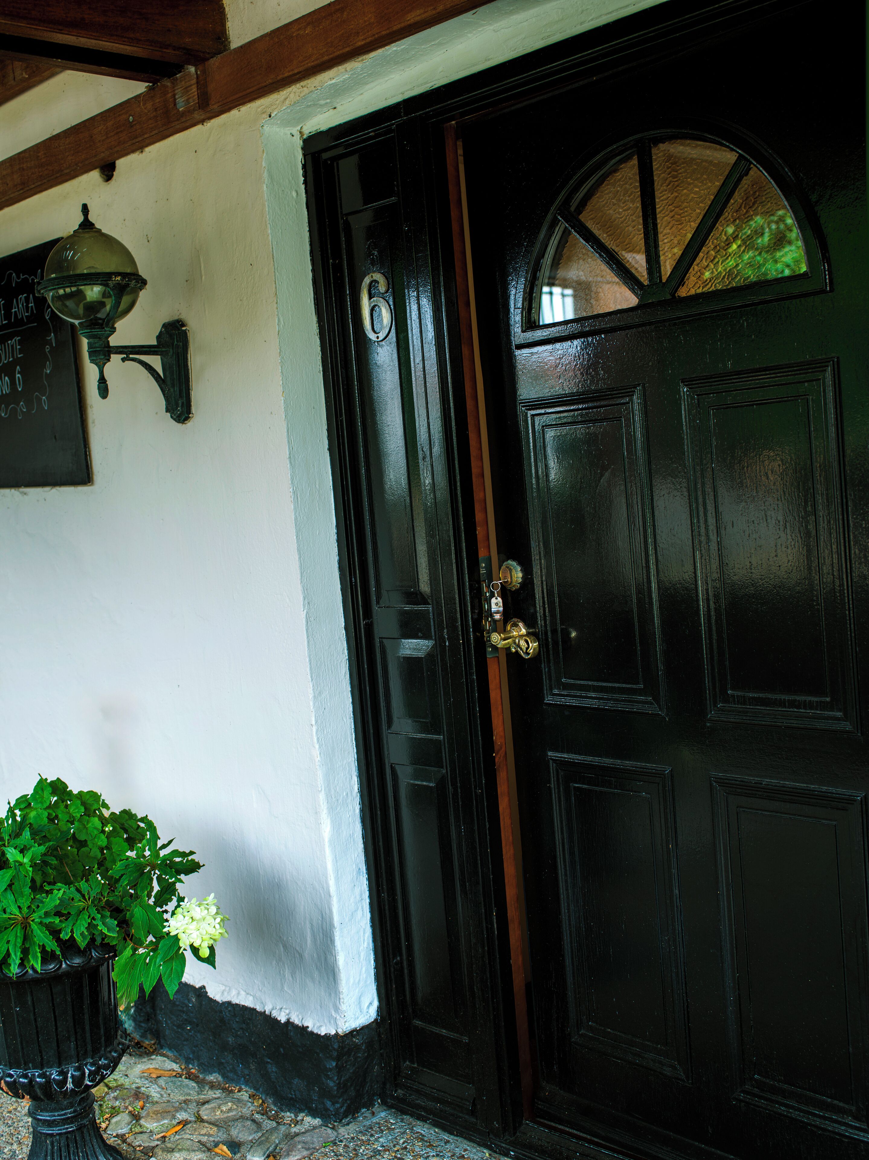 A black door with a brass knocker and a glass panel.