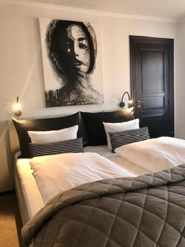 Restful retreat with a large bed, framed artwork, and stylish pillows.
