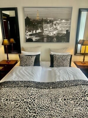 Relax in this stylish room with a large bed, two bedside tables, and a cityscape photograph above.