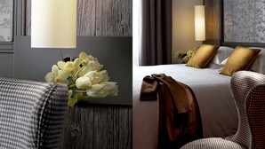 Una habitación de hotel con una pared de acento de madera, una cama con ropa de cama blanca y marrón, y una lámpara.