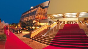 A modern building with a red carpeted staircase leading to an entrance.