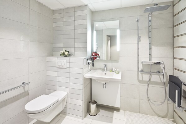 A modern bathroom with a toilet, sink, and shower.