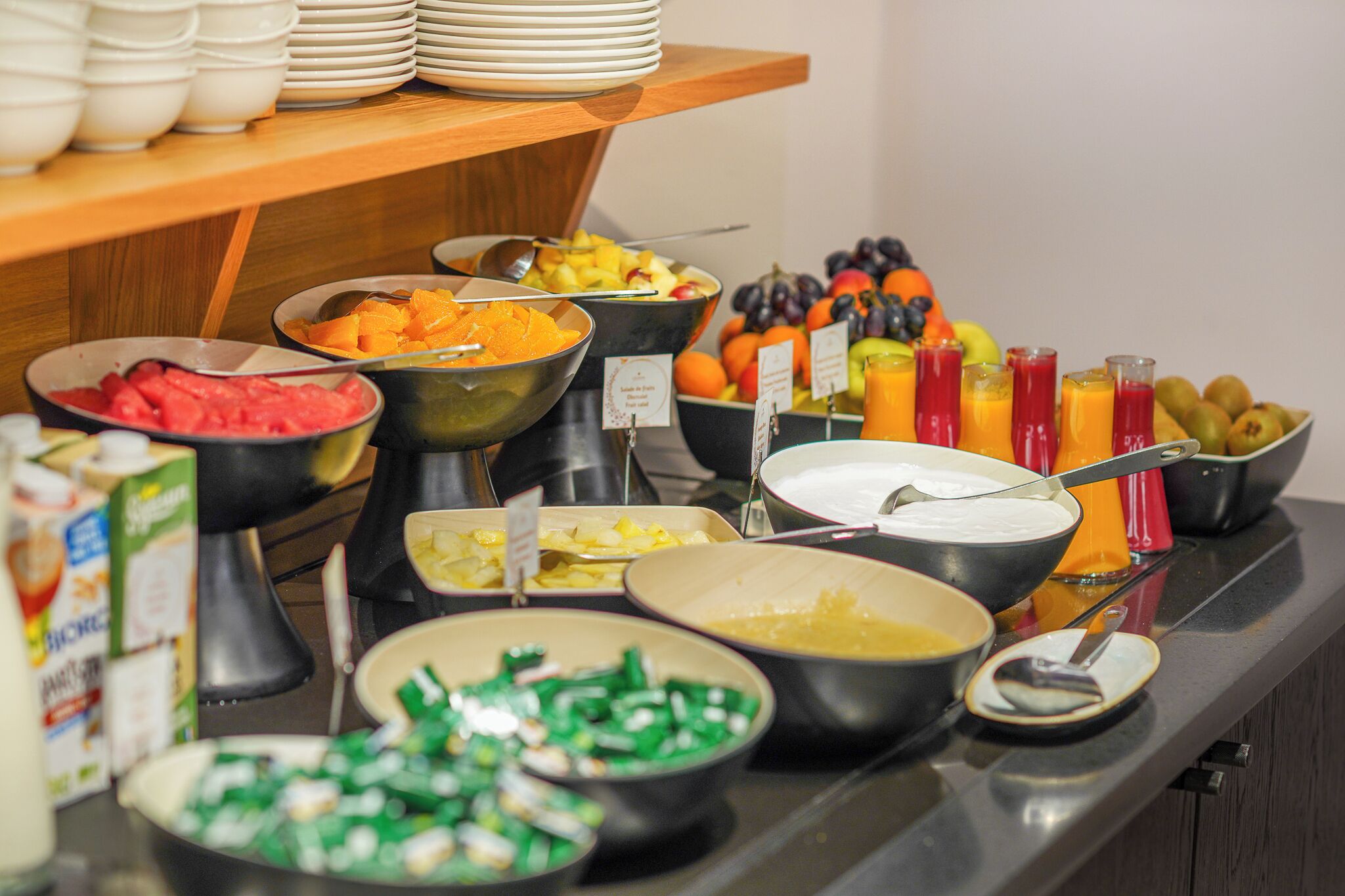 A buffet with various food and drink options, including fruits, vegetables, and juices.