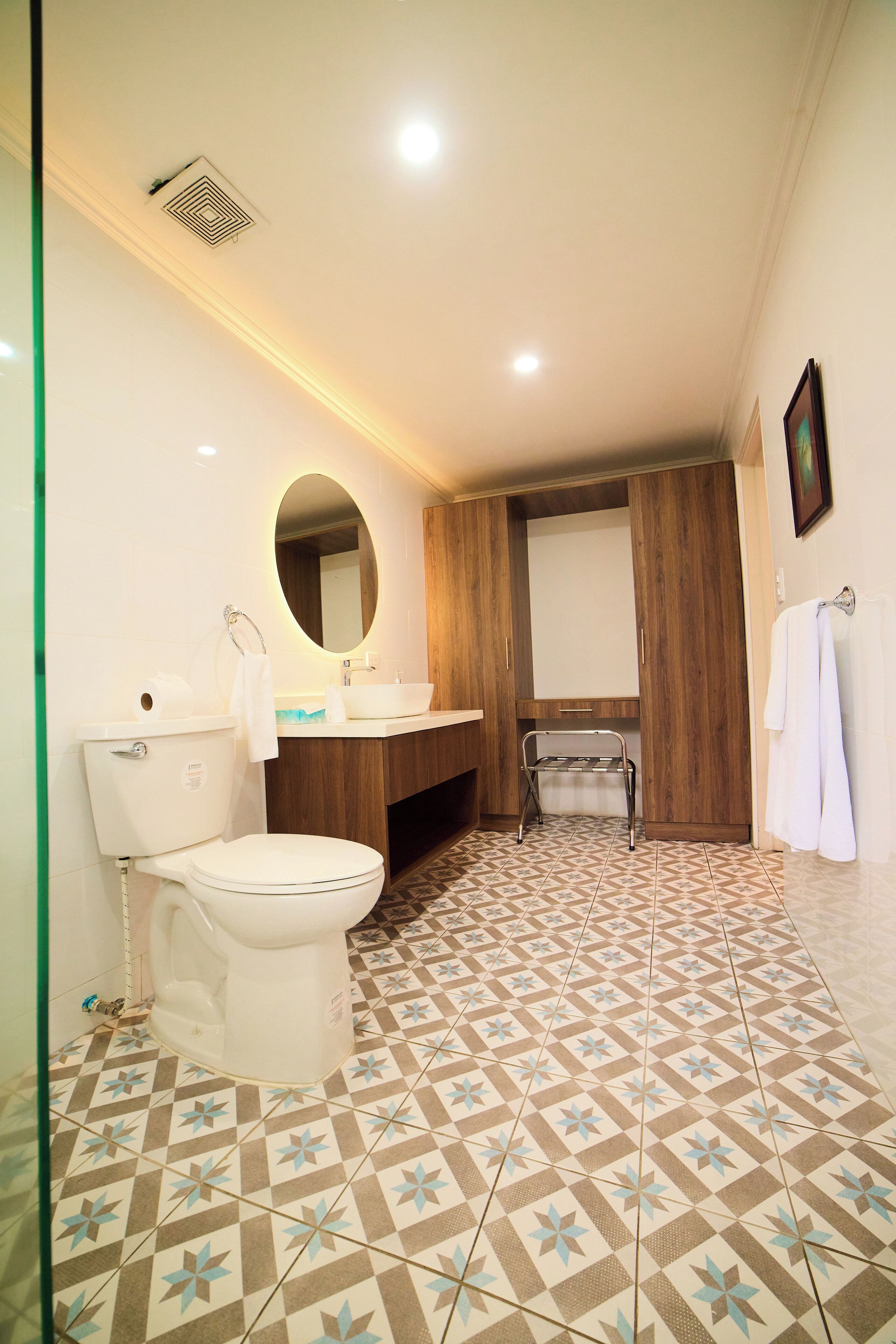 Un bagno con il water, un lavandino, uno specchio e un portasciugamani.