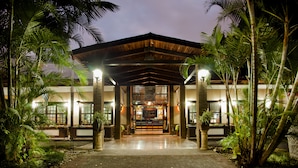 A hotel entrance with a brick facade, a wooden overhang, and a welcoming sign. - El Rodeo Estancia Boutique Hotel & Steakhouse (San Rafael)
