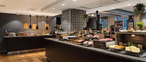 A modern kitchen with a central island, various food items, and a patterned backsplash.