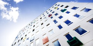 A multi-story building with a modern architectural design, featuring a series of windows and balconies. - Stord Hotell (Stord)