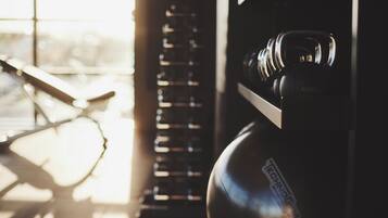 A gym with exercise equipment, including a punching bag and a rack of weights.