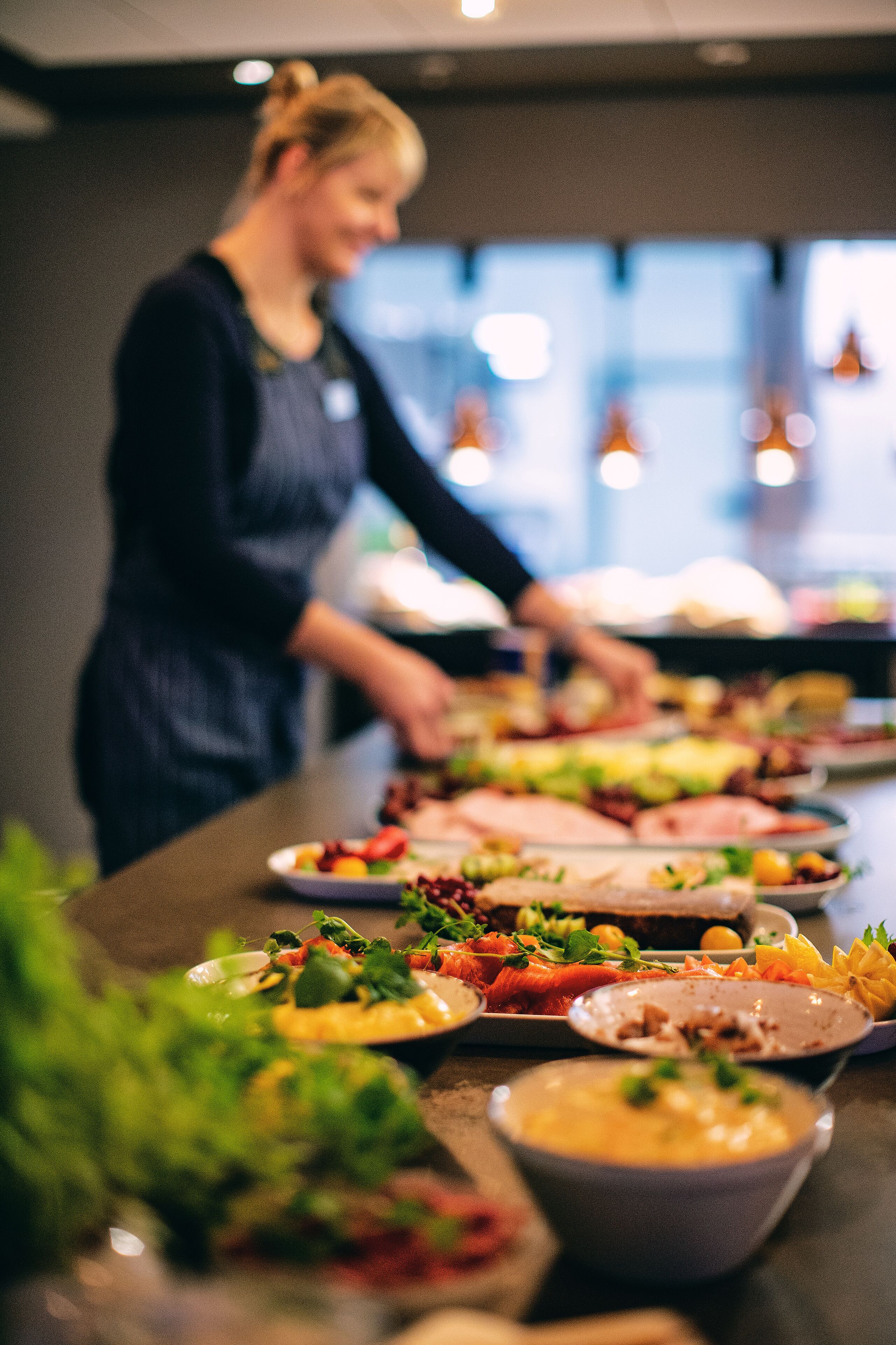 Ein reichhaltiges Buffet mit verschiedenen Speisen und einer Person, die das Essen serviert.