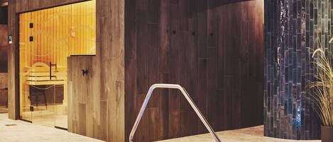 A modern indoor pool area with a wooden wall and a glass door leading to a room.