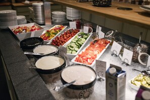 A buffet with various food items and condiments.