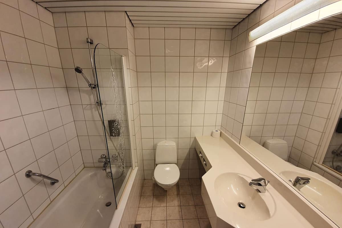 A bathroom with a shower, toilet, and sink.
