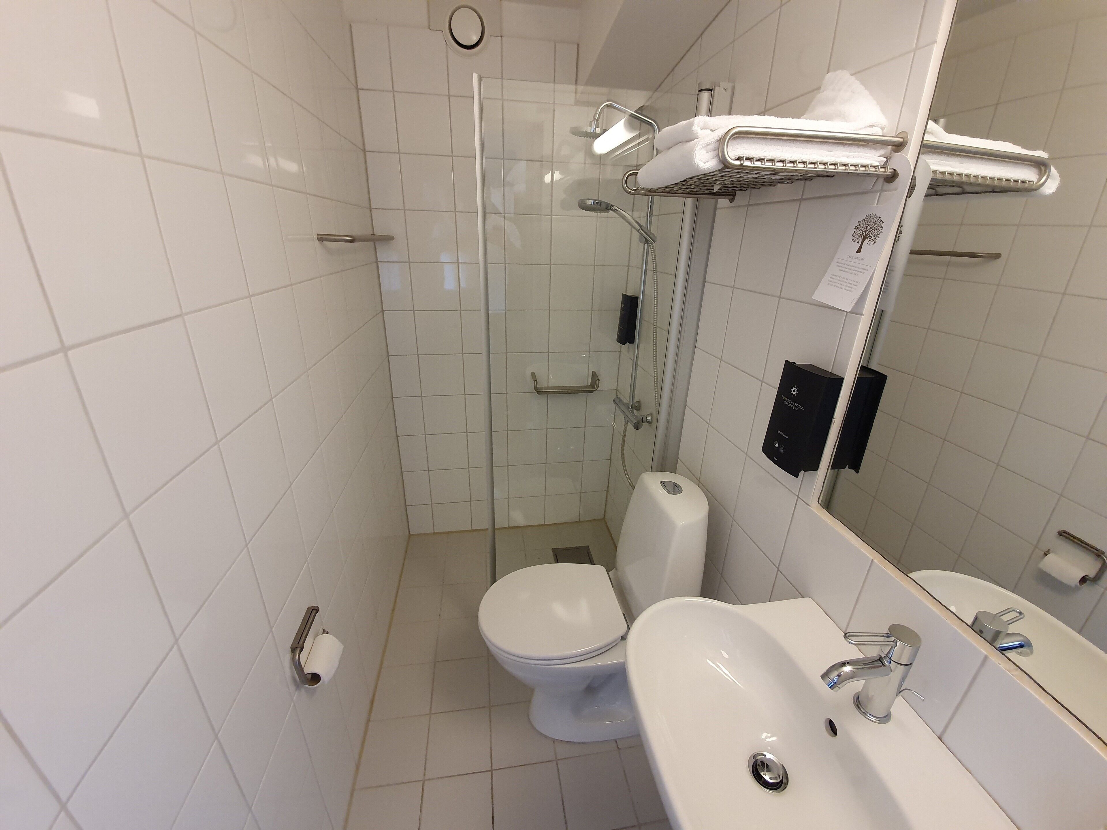 A modern bathroom with a toilet, sink, and shower.
