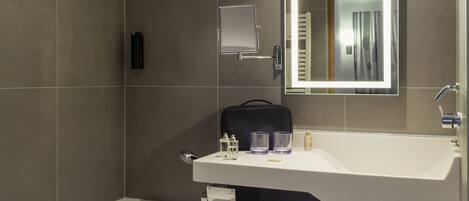 A modern bathroom with a bathtub, a sink with a mirror, and a towel rack.