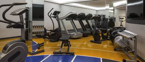 A gym with treadmills, elliptical machines, and weight equipment.