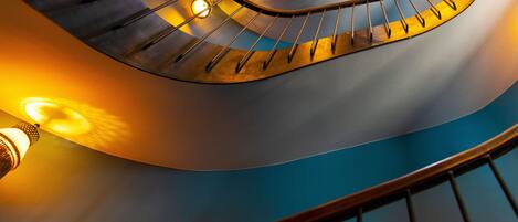 Una escalera de caracol con pared azul y barandilla.