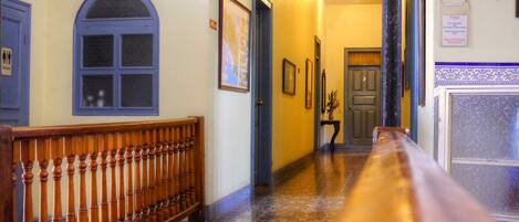 A hallway with a wooden bench, a door, and a tiled floor.