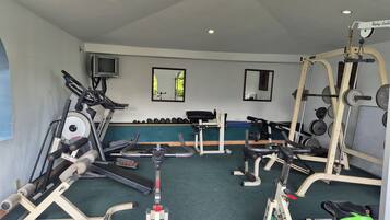 A gym with treadmills, weight machines, and free weights.