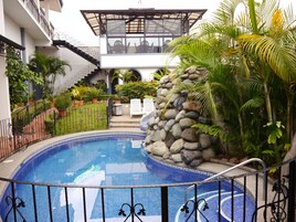 Una piscina al aire libre, sillones reclinables de piscina