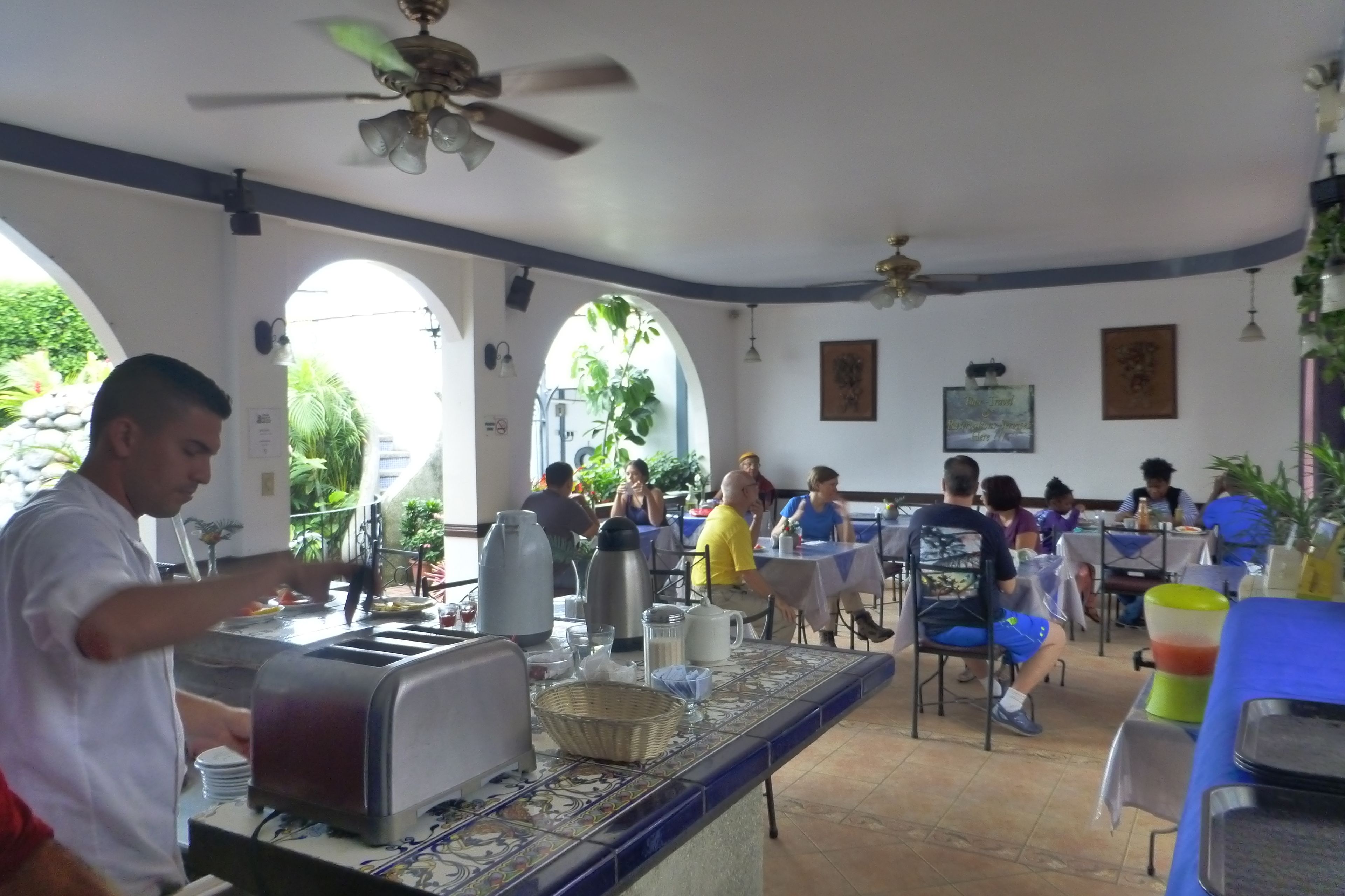 A dining area with tables and chairs, a buffet counter, and ceiling fans.