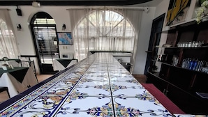 A long, tiled kitchen with a view of the street through a window.