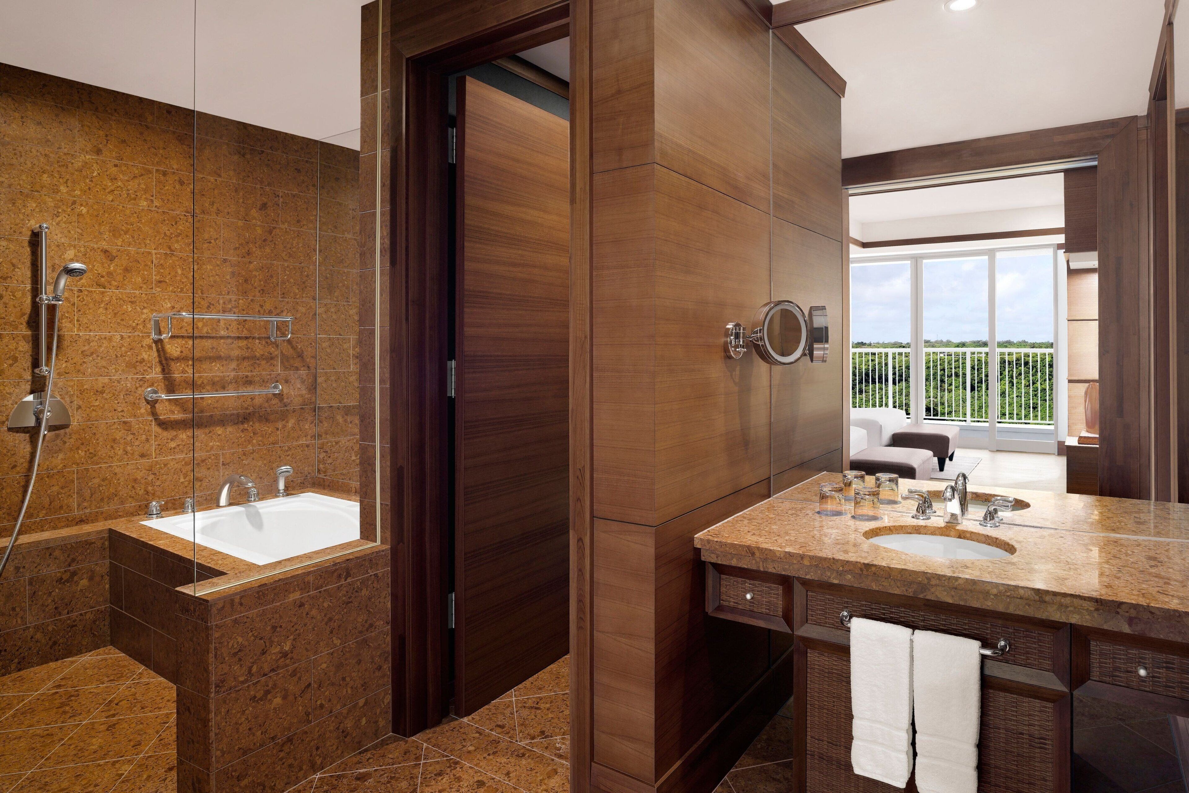 A modern bathroom with a large bathtub, a double sink vanity, and a glass shower enclosure.