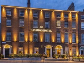 Un edificio de hotel con un letrero llamativo que dice 'CASSIDYS HOTEL' y una entrada bien iluminada.